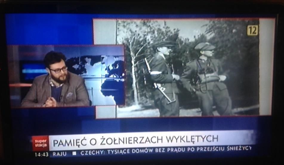 Fig. 2. Frozen frame from Superstacja’ “Raport”. Guest in the smaller screen and a picture of some unbroken soldiers. The title of this part “Pamięć o żołnierzach wyklętych”