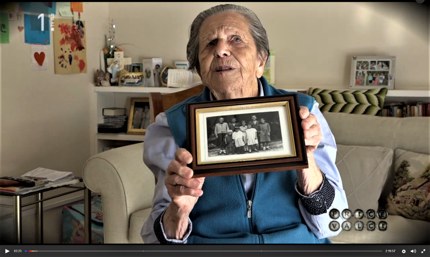 Francka Anžin, showing an old photograph of her and her siblings.